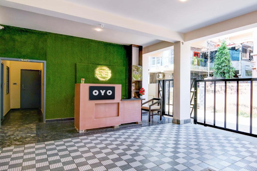 an empty lobby with aqo sign on a green wall at OYO Flagship SS INN Hotels & Homes in Khandagiri