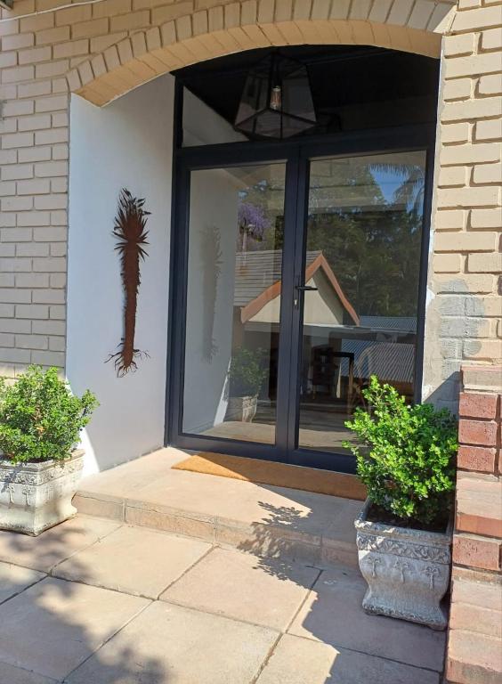 a front door of a house with a palm tree on the wall at Buckingham Studio in Pinetown