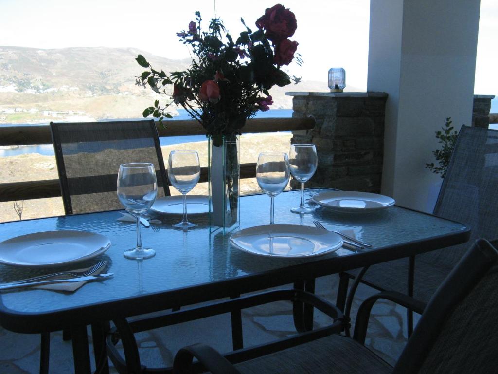 a table with wine glasses and a vase with flowers at De La Rocka in Sinétion