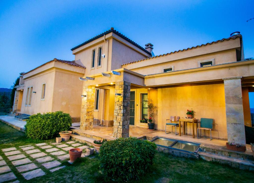 a house with a patio and a table in front of it at Villa Porgio Mountain View in Serres