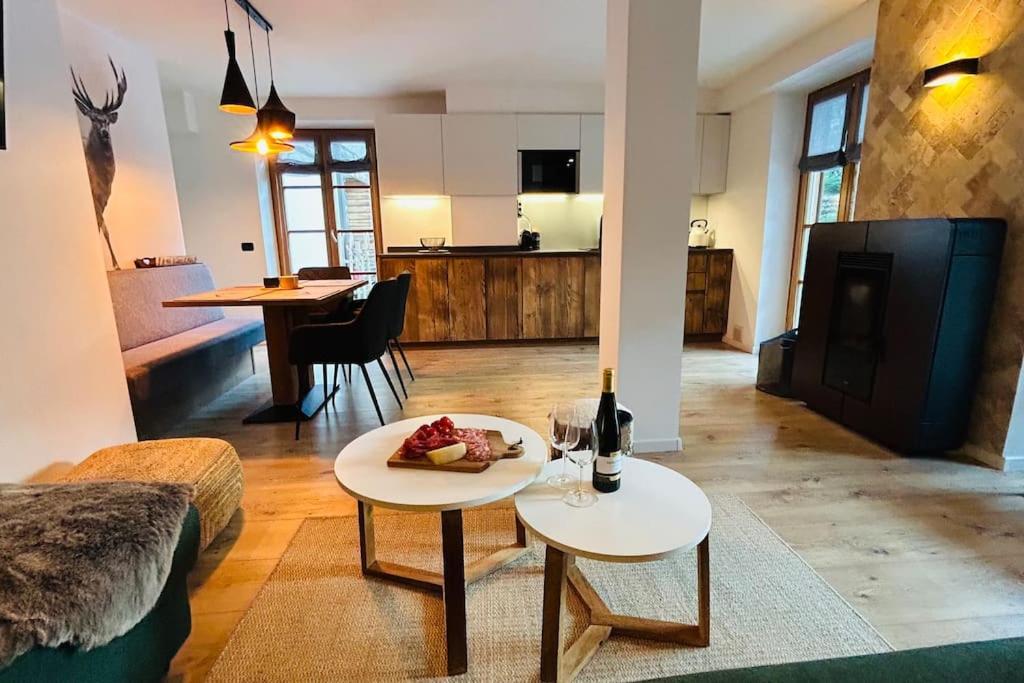 a living room with a table with a plate of food on it at Alpen Lodge Premium Apartment in Mezzana