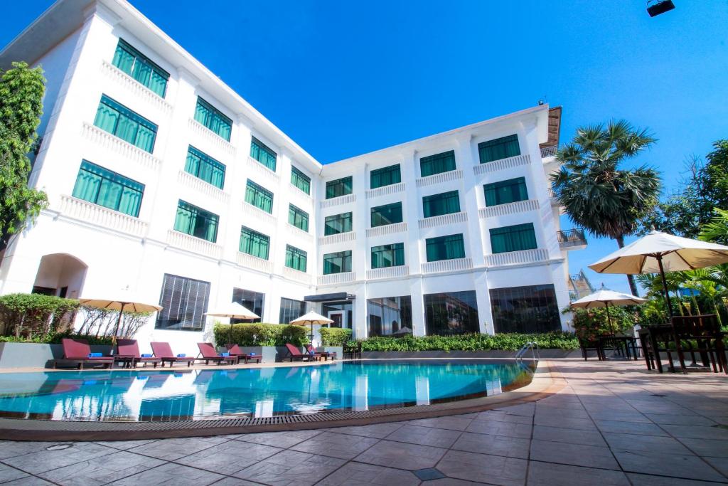 a hotel with a swimming pool in front of a building at Kingdom Angkor Hotel in Siem Reap