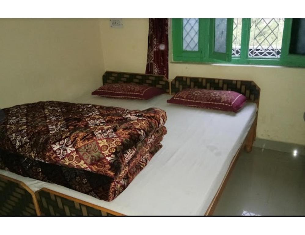 Anoop Tourist Guest House, Phata في Phata: سرير في غرفة عليها وسادتين