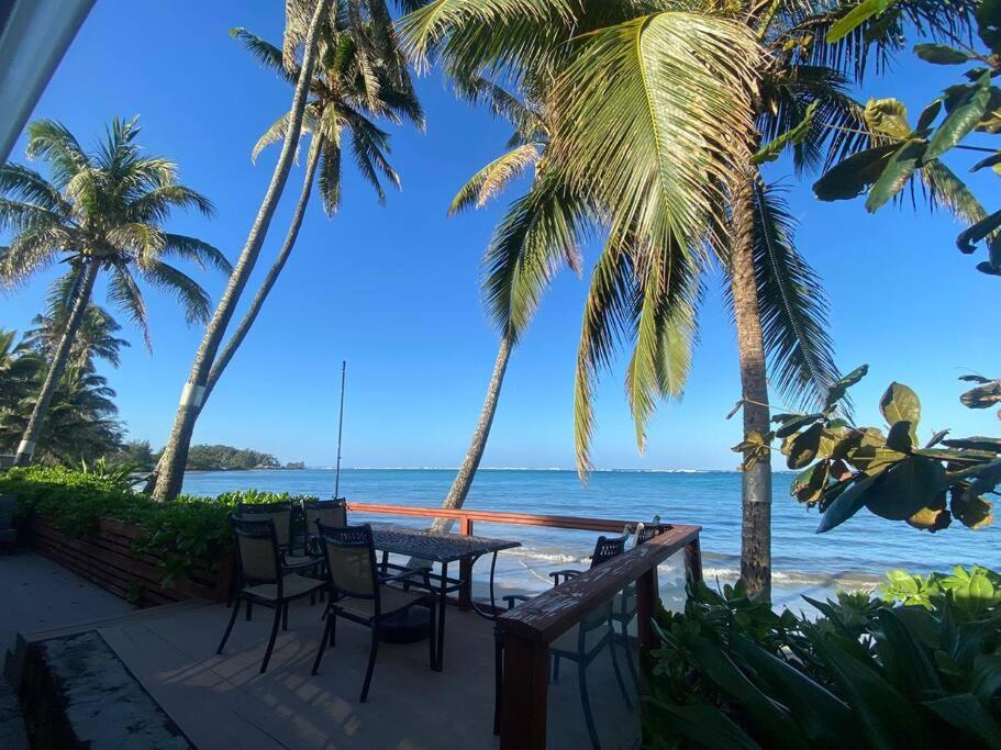 una mesa y sillas en la playa con palmeras en Tranquil Beachfront Duplex-type Private House!, en Hauula