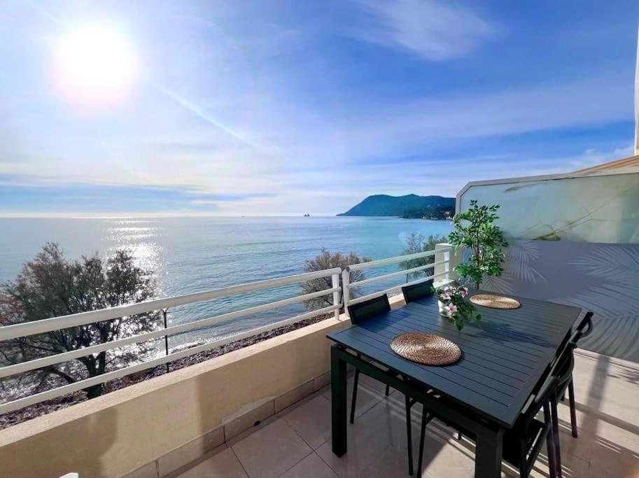 une table sur un balcon avec vue sur l'eau dans l'établissement La Mer Résidence La Fontaine, à La Seyne-sur-Mer