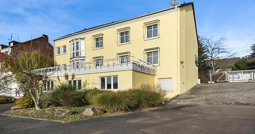 a yellow building with a balcony on the side of it at CityChalet Business Apartments - Workers welcome! - Free Parking - Fast WIFI - Smart TV - WM in Saarbrücken