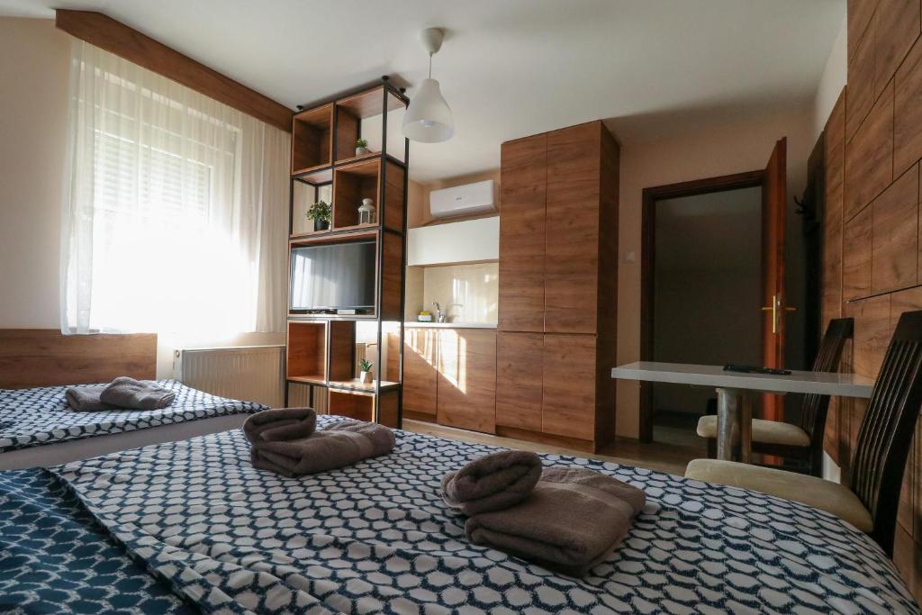 a bedroom with two beds with brown pillows on them at Studio Apartments Maksimović in Niš