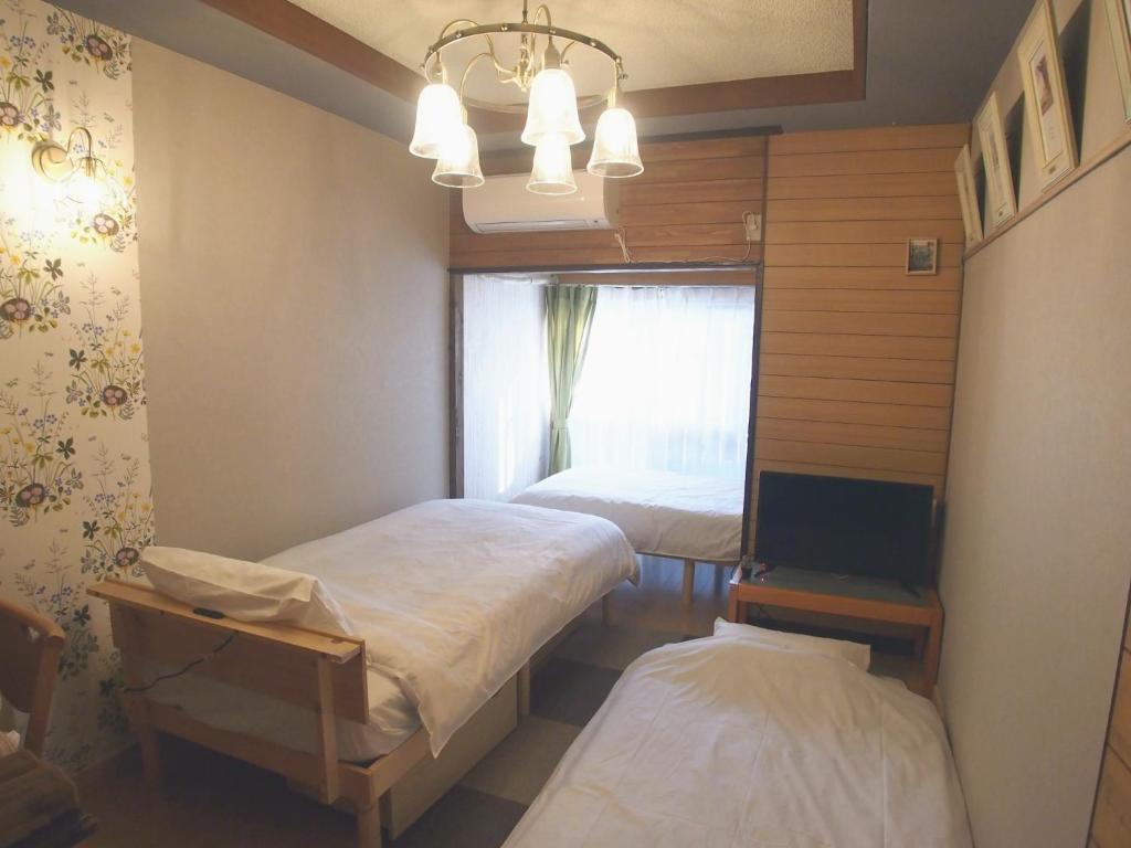 a room with two beds and a tv and a window at Classy Busshozan - Vacation STAY 15858 in Takamatsu