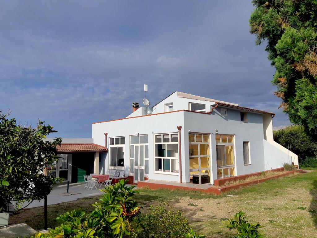 een wit huis met ramen en een tuin bij Casa Ananda in Sorso