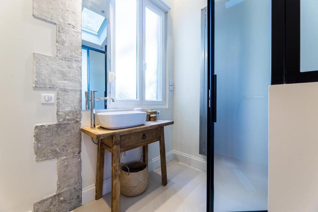 a bathroom with a sink and a window at ALOE KEYWEEK Architect Apartment with terrace and garage Biarritz in Biarritz