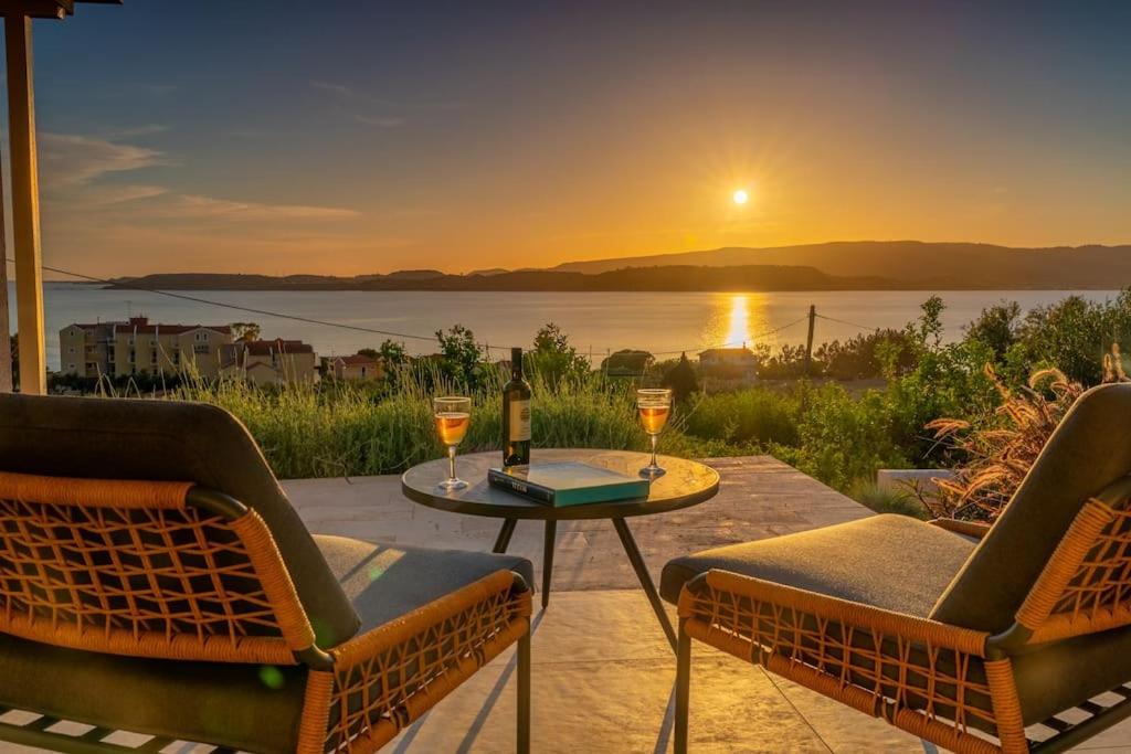 a patio with two chairs and a table with wine glasses at THALASSA VIEW RESIDENCE in Argostoli