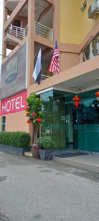 a hotel with flags in front of a building at Mass Boutique Hotel in Mentekab