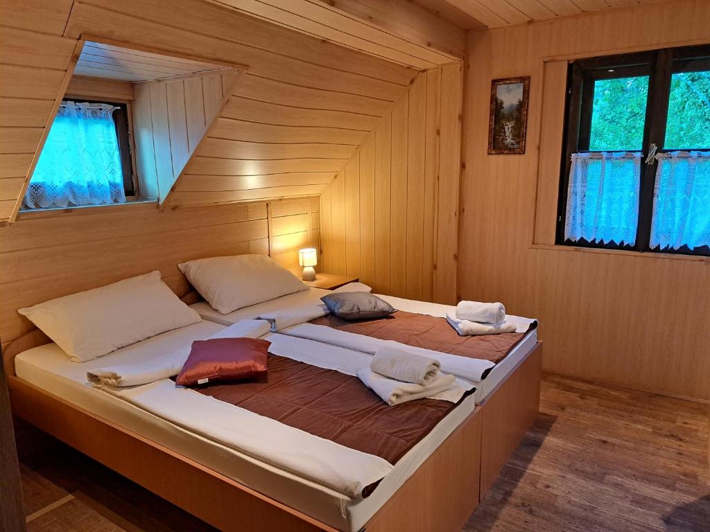 sypialnia z 2 łóżkami w drewnianym pokoju w obiekcie San Korana w mieście Jeziora Plitwickie
