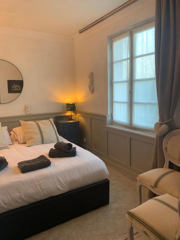 a bedroom with a bed and a window and a chair at Petit Boudoir The Riverside Retreat in Triac-Lautrait