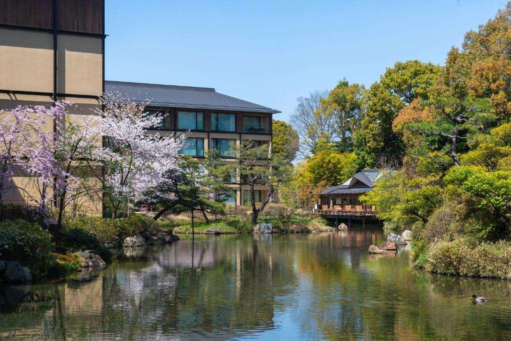 Four Seasons Hotel Kyoto في كيوتو: اطلاله على نهر مع عماره واشجار