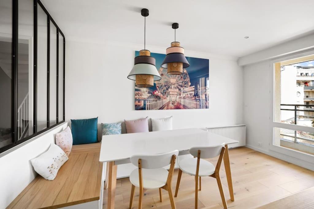 une salle à manger avec une table et des chaises blanches dans l'établissement Spacious duplex with terraces, à Boulogne-Billancourt