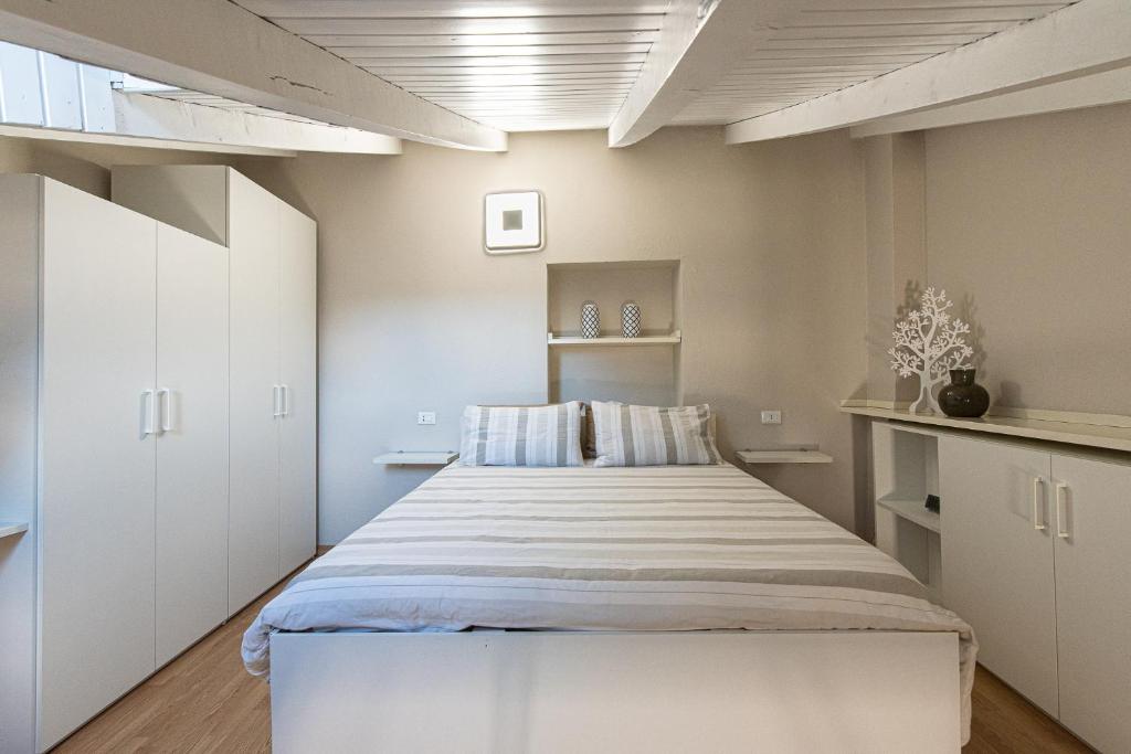 La Casetta di Tiffi - Borgo Lovere في لوفيري: غرفة نوم بسرير ودواليب بيضاء
