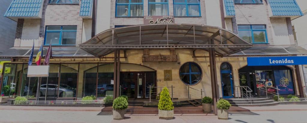 a building with a round entrance to a store at Hotel Villa Natali in Chişinău