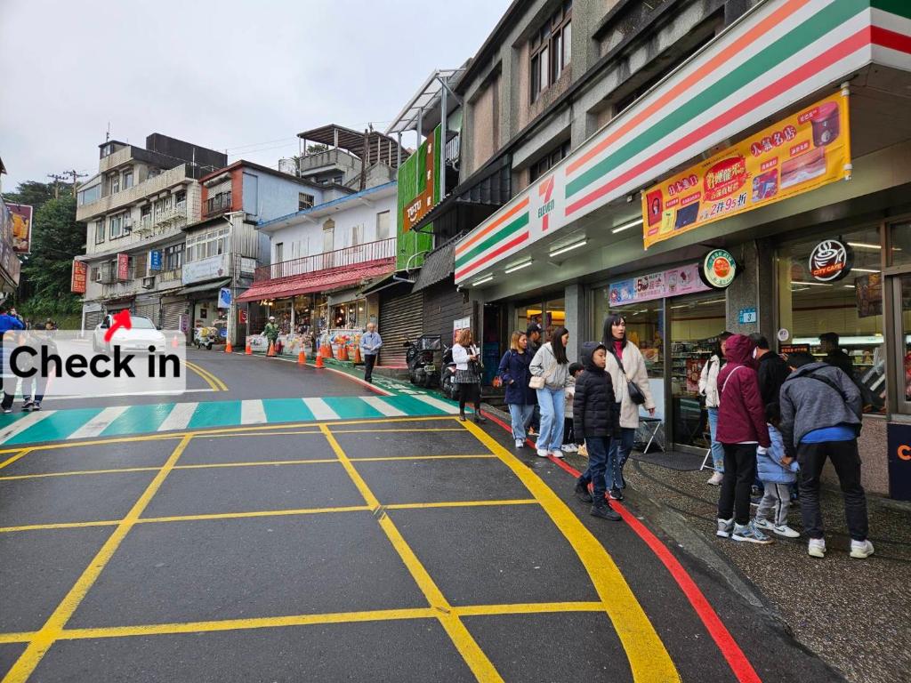 um grupo de pessoas em pé em uma rua da cidade em Ching Yue B&B em Jiufen