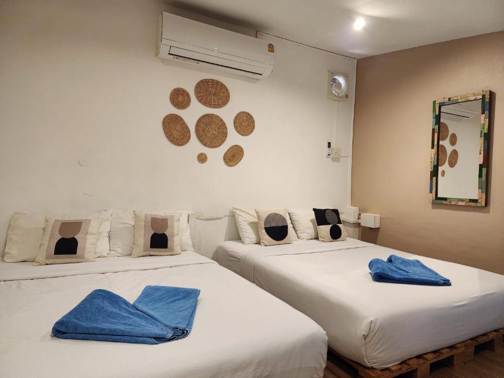twee bedden in een kamer met blauwe handdoeken erop bij Baan Minnie 3 bedroom house 400m from Saikaew beach in Ko Samed