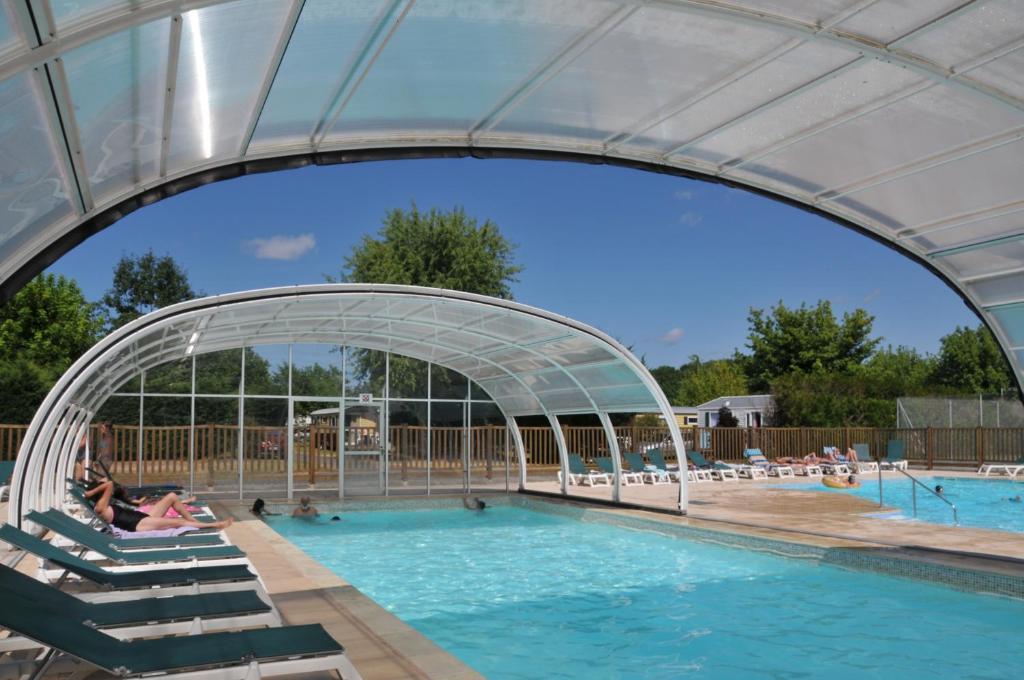 a swimming pool with an archway over it at Camping La Mignardière in Ballan-Miré
