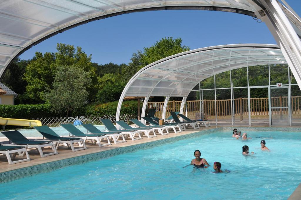 a group of people swimming in a swimming pool at Camping La Mignardière in Ballan-Miré