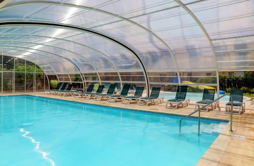 a swimming pool with a glass roof over it at Camping La Mignardière in Ballan-Miré
