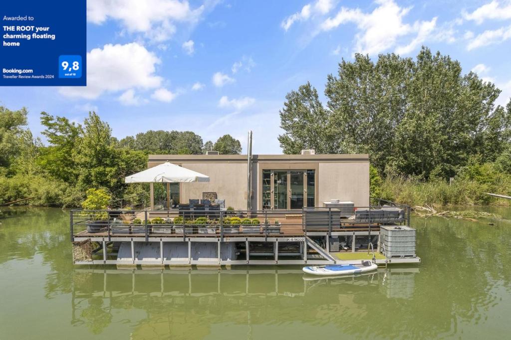 a house on a dock on a body of water at THE ROOT your charming floating home in Bratislava