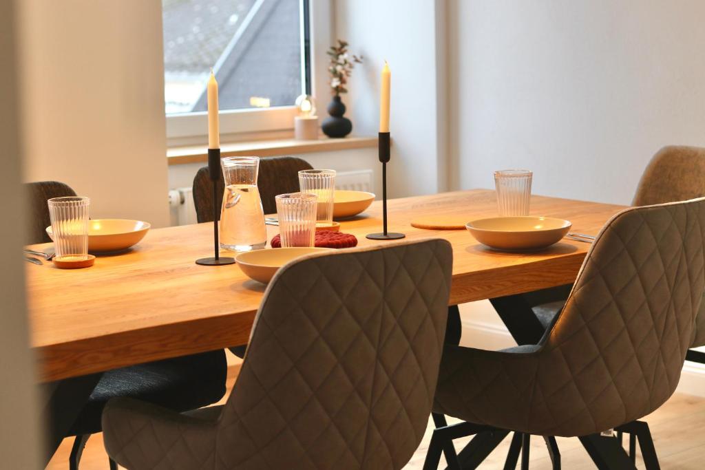 特拉本特拉巴赫的住宿－Moderne Ferienwohnung，木制餐桌,配有椅子和蜡烛