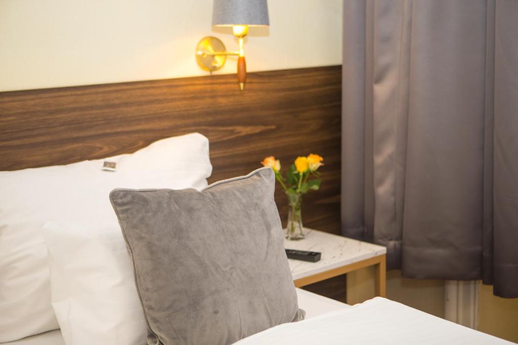Un dormitorio con una cama y una mesa con un jarrón de flores en City Pension Stephansplatz I Self Check In, en Viena
