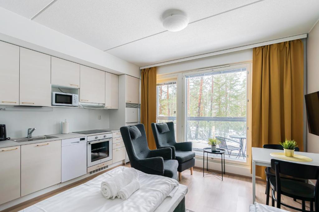 a kitchen and living room with a table and chairs at Hiisi Homes Porvoo Toukovuori in Porvoo