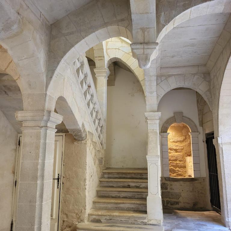 - un escalier dans un bâtiment ancien avec des arches dans l'établissement Uzès, au cœur du centre médiéval La Boussole d'Uzès, appartement de caractère du XVII -ème siècle, à Uzès