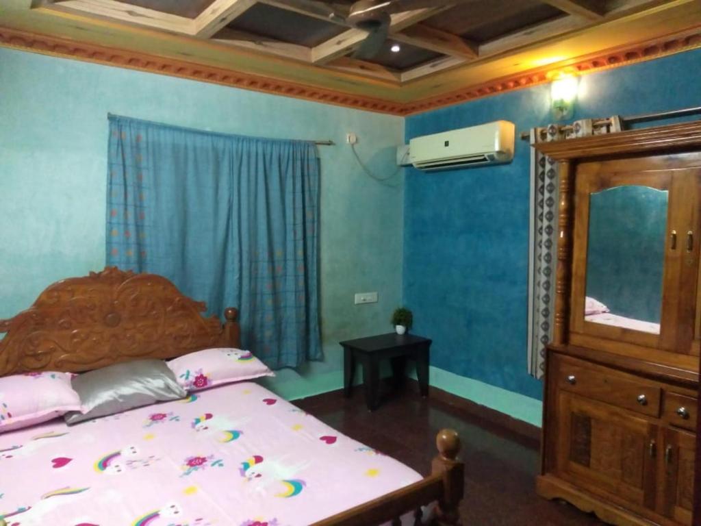 - une chambre avec un lit, une commode et un miroir dans l'établissement MN Homestay, à Varkala