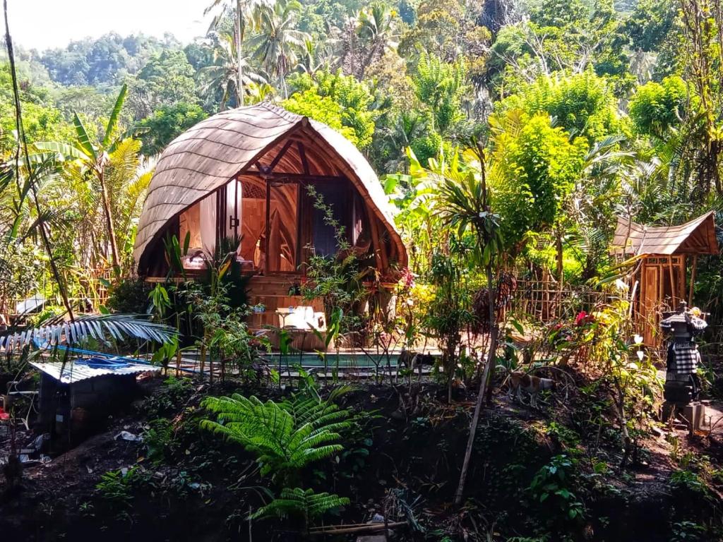 uma pequena casa na árvore no meio de uma floresta em Bamboo House - Ecobreeze em Sidemen