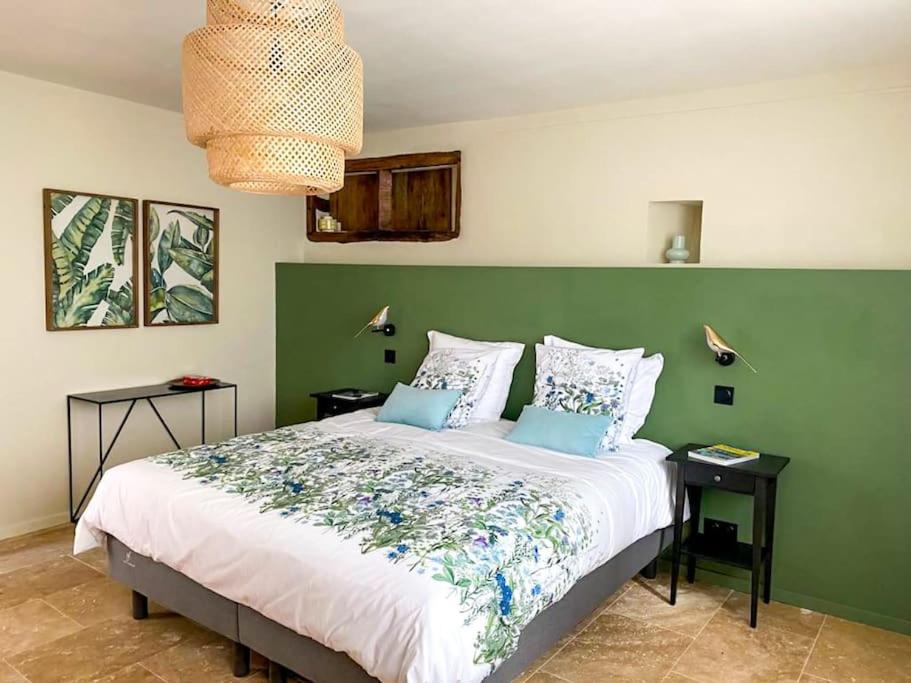 1 dormitorio con 1 cama grande y pared verde en Le gîte des vieux Montils, en Les Montils