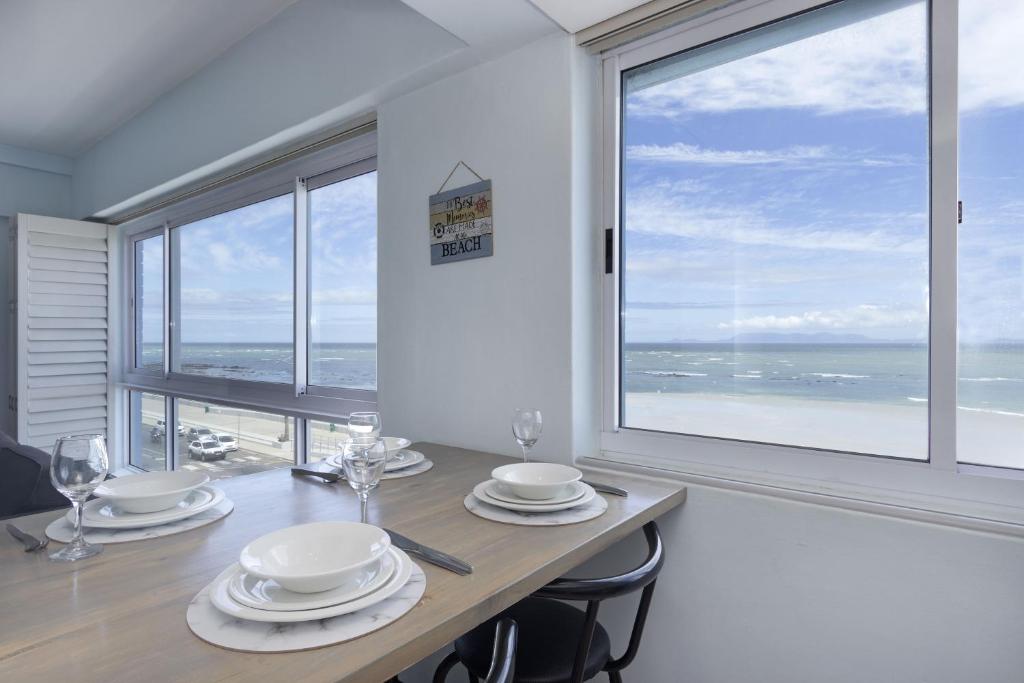 a dining room with a table with a view of the ocean at Pips Place 301 in Strand