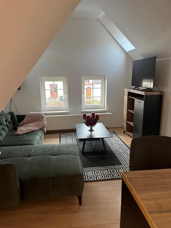 ein Wohnzimmer mit einem Sofa und einem Tisch in der Unterkunft I. Ferienhaus Rathmannsdorfer in Bernburg