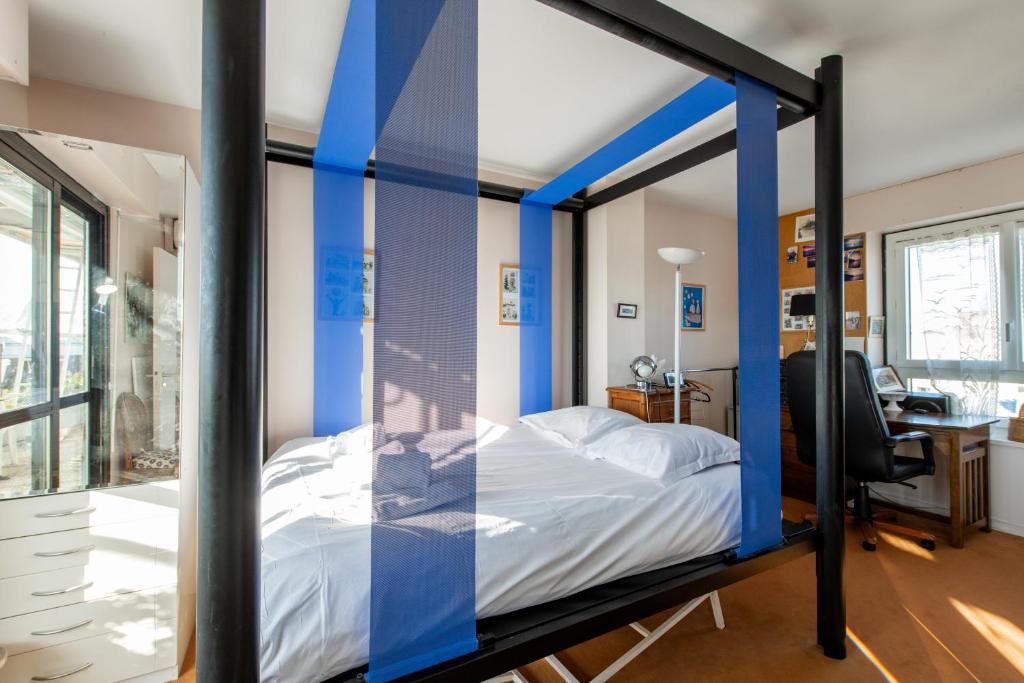 a bedroom with a bed with blue stripes at 120 Grenelle - Spacieux Duplex avec vue sur la tour Eiffel in Paris
