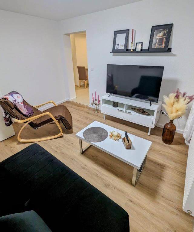 un salon avec un canapé et une télévision dans l'établissement Bietigheimer Hideaway - Modern und Gemütlich, à Bietigheim