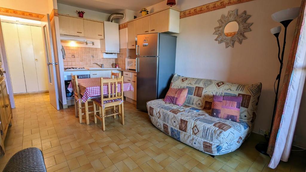 ein Wohnzimmer mit einem Sofa und einer Küche in der Unterkunft 5037 Sentosa 20B in Cap d'Agde