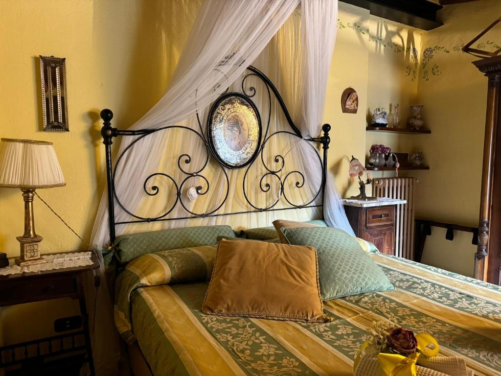 um quarto com uma cama e uma cabeceira em ferro forjado em Casa Giulia, il gioiello del Borgo em Certaldo