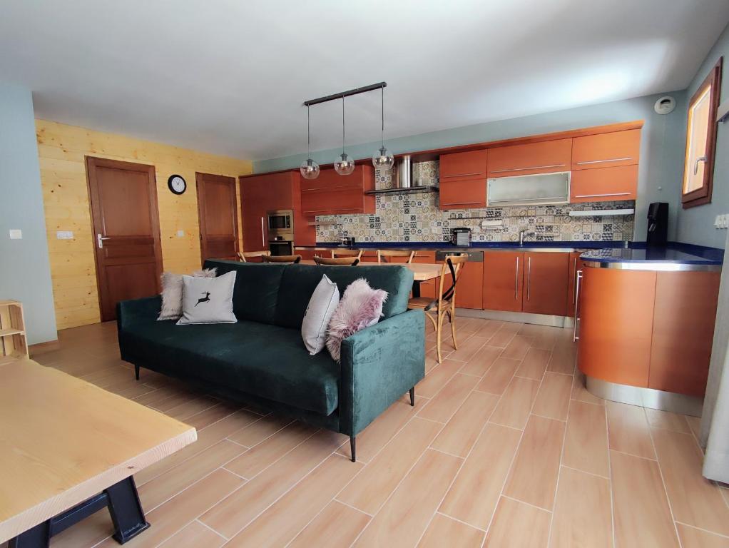 Il comprend un salon avec un canapé vert et une cuisine. dans l'établissement Luxueux appartement T4 skis aux pieds à Tignes le Lac, à Tignes