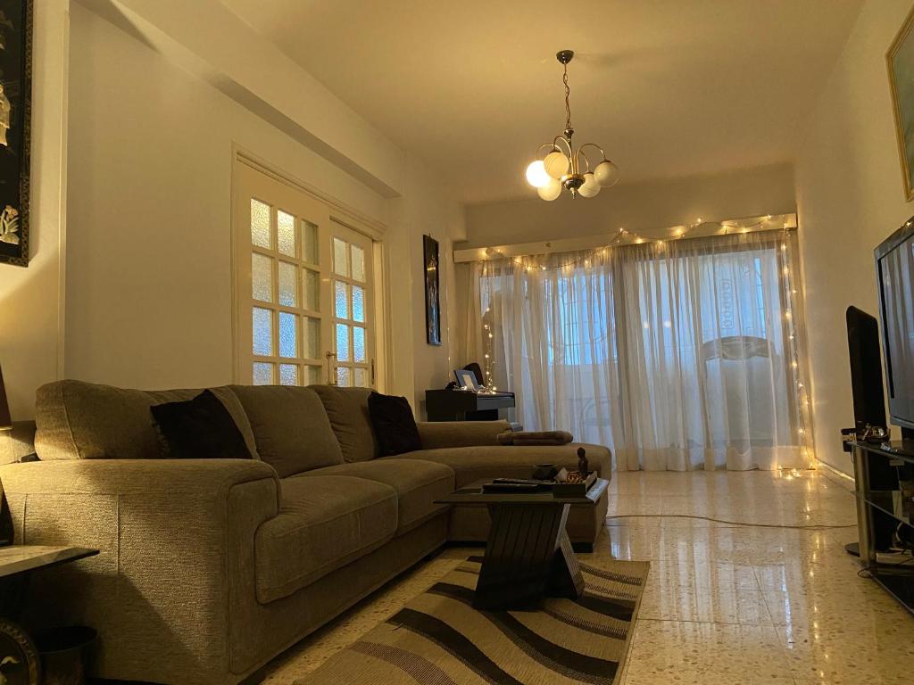 a living room with a couch and a table at Comfortable 2BR Apartment & Office & Fitness Room in Ayios Dhometios