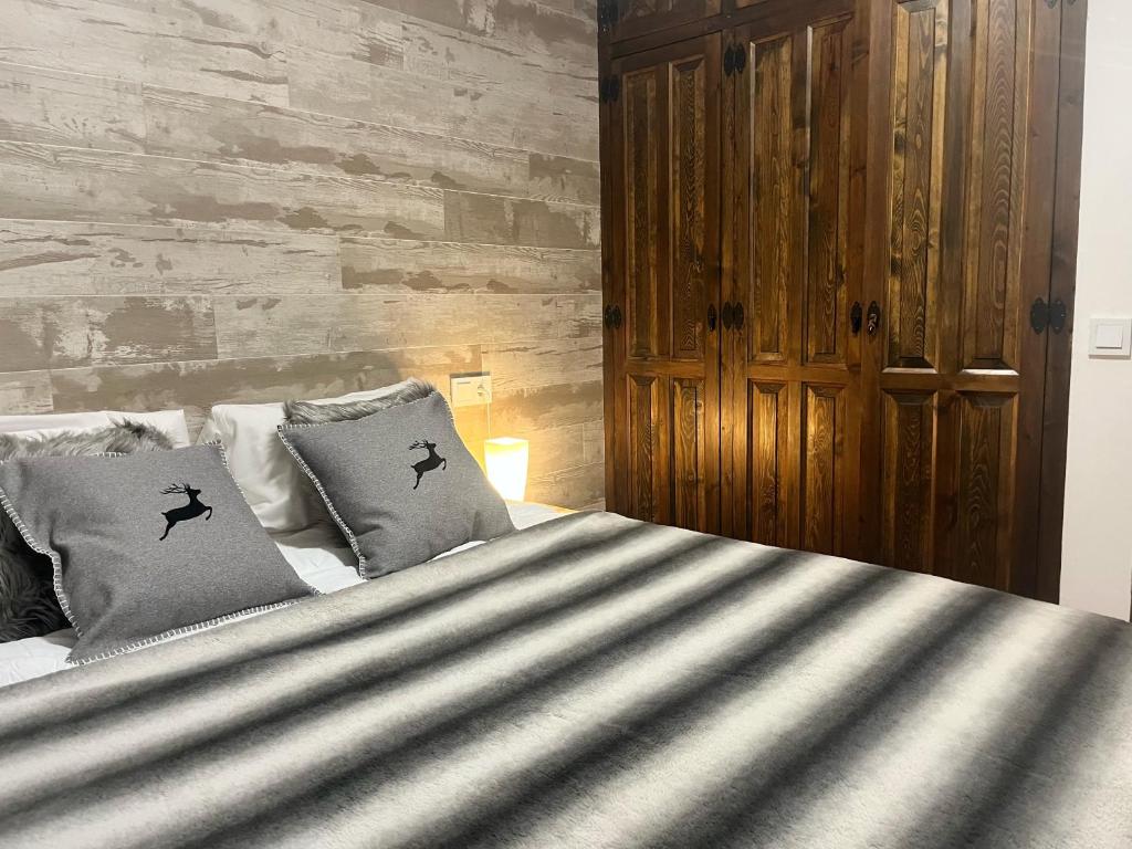 una camera da letto con un grande letto con due cuscini di Apartamento Mirador Encamp a Encamp