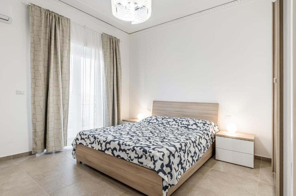 ein weißes Schlafzimmer mit einem Bett und einem Fenster in der Unterkunft Catania Roomy & Modern Apartment - Balconies in Catania
