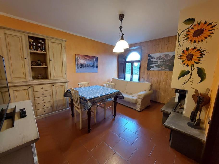 un salon avec une table et un canapé dans l'établissement Appartamento Abetone vicino alle piste da sci!, à Abetone
