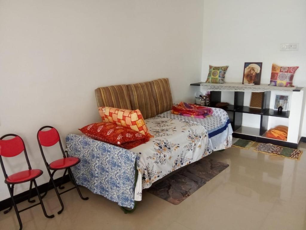 1 dormitorio con 1 cama, 1 silla y 1 estante en Trishul holidays, en Alāndurai