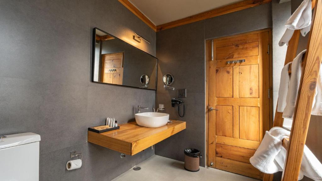 a bathroom with a sink and a mirror at Chospa Hotel, Leh in Leh