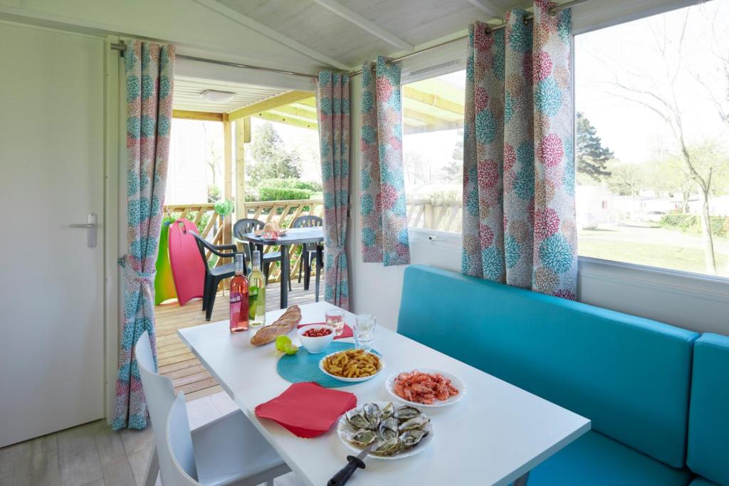 a dining room with a table with food on it at Camping La Mignardière in Ballan-Miré