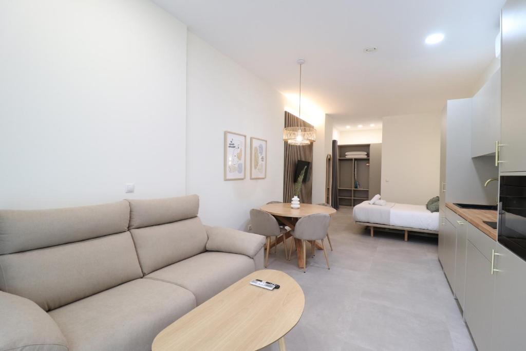 ein Wohnzimmer mit einem Sofa und einem Tisch in der Unterkunft Favara Flats by Concept in Valencia